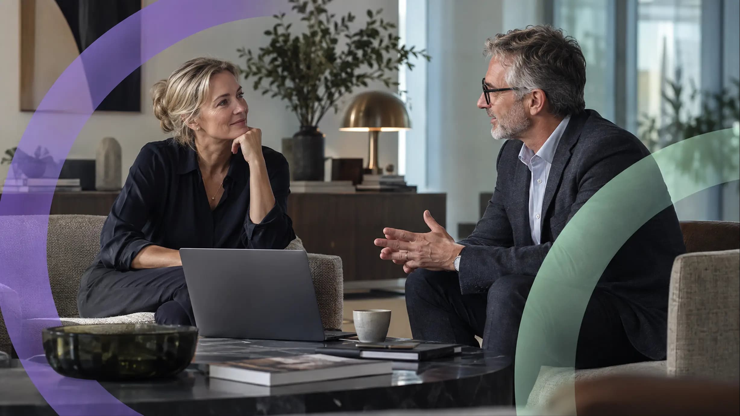 Two professionals talking across a table in an office lounge