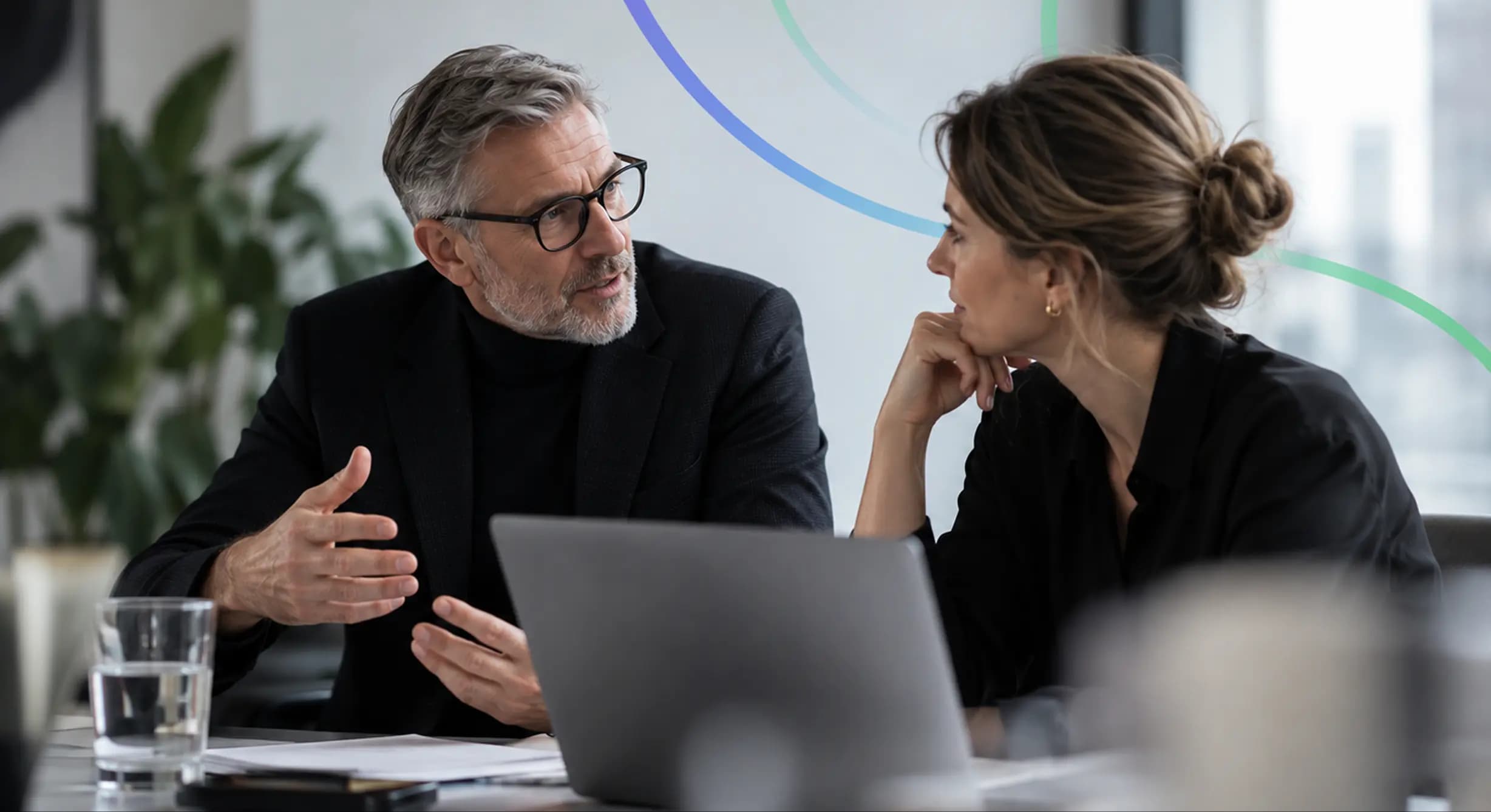 Two colleagues discussing work over a laptop